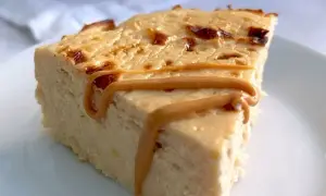 Rebanada de tarta de queso al horno con caramelo líquido.