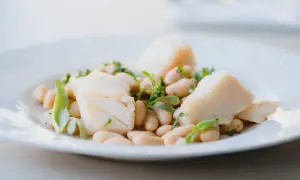 Deliciosa ensalada de bacalao con tiernos garbanzos y hierbas frescas, un plato ligero y sabroso.