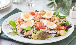 Deliciosa ensalada de garbanzos con huevo duro, tomate, aceitunas y cebolla morada. Un plato fresco y nutritivo.