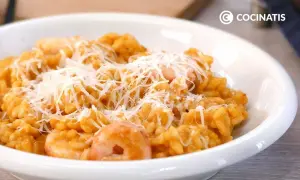 Un cremoso risotto de gambas, cubierto con queso rallado, listo para disfrutar.