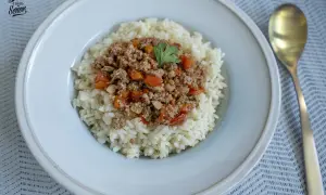 Un plato de arroz blanco cubierto con una sabrosa mezcla de arroz con carne picada, tomates y pimientos.
