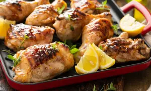 Muslos de pollo dorados y jugosos, asados a la parrilla con hierbas frescas y gajos de limón. ¡Un festín para los sentidos!