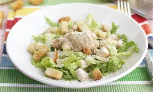 Ensalada César con pollo, lechuga, crutones y queso rallado. Los ensalada cesar ingredientes se ven frescos y apetitosos.