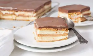 Una porción de tarta de la abuela, con capas de galleta y crema, cubierta de chocolate.