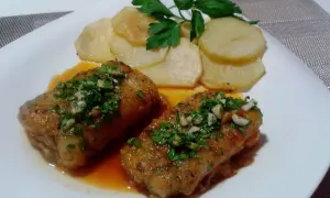 Dos trozos de bacalao a la llauna con patatas y perejil.