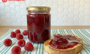 Tarro de mermelada de frambuesa casera, con frambuesas frescas y una tostada untada. ¡Un placer para el paladar!