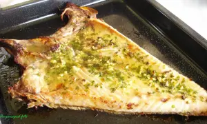 Deliciosa ventresca al horno, dorada y jugosa, con un aderezo de ajo y perejil.