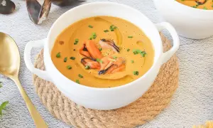 Crema de marisco con mejillones, un delicioso pate de mejillones servido en un cuenco blanco con cebollino y aceite de oliva.