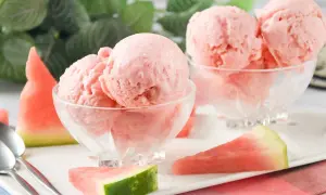 Dos copas de cremoso helado de sandía, decoradas con trozos de fruta fresca. ¡Un postre refrescante!