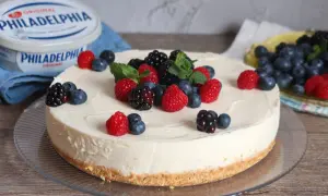 Deliciosa tarta de queso fría cubierta con frambuesas, moras y arándanos frescos. Un postre perfecto para cualquier ocasión.