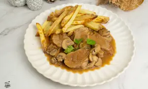 Solomillo en salsa de la abuela con champiñones y patatas fritas. Un plato casero que evoca recuerdos.