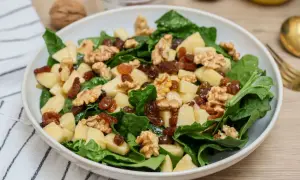 Deliciosa ensalada de espinacas con trozos de manzana, pasas y nueces. Una combinación crujiente y dulce.