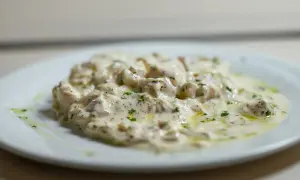 Deliciosa brandada de bacalao cremosa, espolvoreada con perejil fresco y un toque de aceite de oliva.