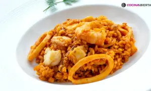 Arroz del senyoret con gambas, calamares y trozos de pescado blanco, servido en un plato blanco.
