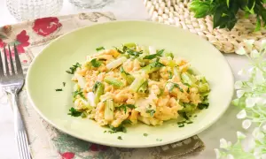 Revuelto de ajetes con perejil fresco, servido en un plato verde claro. Un desayuno ligero y sabroso.