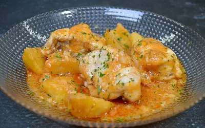 Rape en salsa marinera con patatas, adornado con perejil picado.
