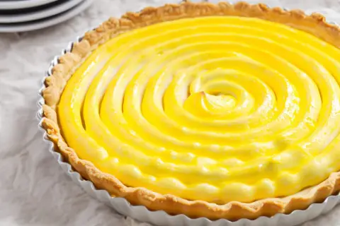 Tarta de limón con merengue, con una espiral dorada y cremosa que invita a probarla.