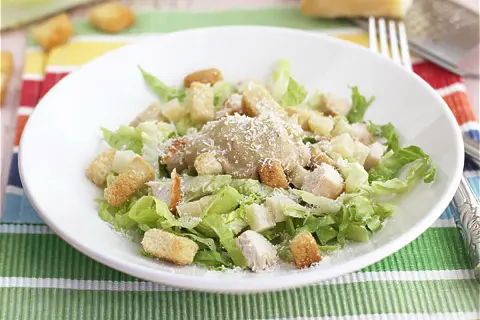 Ensalada César con pollo, lechuga, crutones y queso rallado. Los ensalada cesar ingredientes se ven frescos y apetitosos.