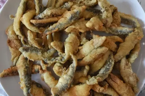 Un plato lleno de boquerones a la andaluza, crujientes y dorados, listos para disfrutar.