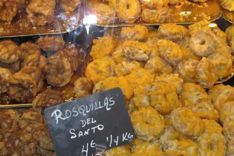 Rosquillas de San Isidro, dulces tradicionales con glaseado amarillo y marrón, listos para disfrutar.