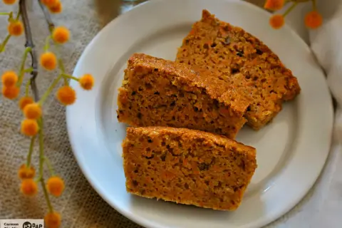 Rebanadas de tarta de zanahoria casera, esponjosas y con trocitos de zanahoria, servidas en un plato blanco.