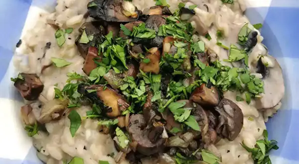 Delicioso risotto de setas cremoso, coronado con champiñones salteados y perejil fresco picado.