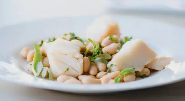 Deliciosa ensalada de bacalao con tiernos garbanzos y hierbas frescas, un plato ligero y sabroso.