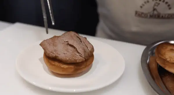 Un delicioso pepito de ternera, jugoso y tierno, listo para ser servido sobre un panecillo.