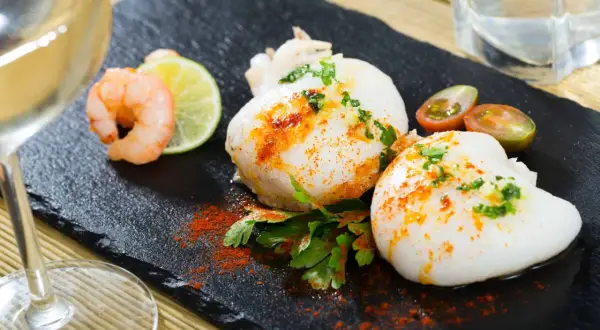 Deliciosa sepia en freidora de aire, servida con gambas, lima y tomates cherry.