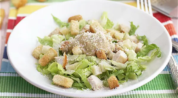 Ensalada César con pollo, lechuga, crutones y queso rallado. Los ensalada cesar ingredientes se ven frescos y apetitosos.