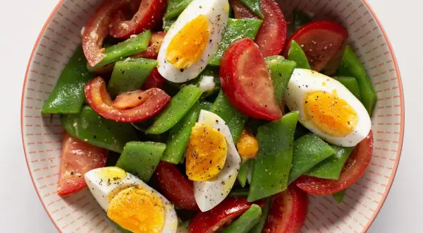 Ensalada de tomate, judías verdes y huevos duros, un plato fresco y nutritivo.