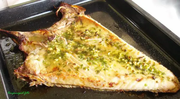 Deliciosa ventresca al horno, dorada y jugosa, con un aderezo de ajo y perejil.