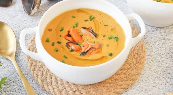 Crema de marisco con mejillones, un delicioso pate de mejillones servido en un cuenco blanco con cebollino y aceite de oliva.