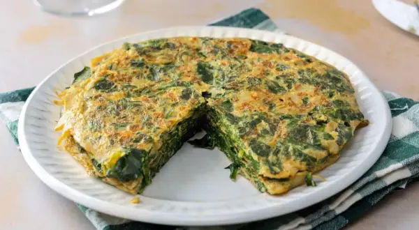 Tortilla de espinacas, un plato casero y saludable. La tortilla de espinacas se ve jugosa y bien cuajada, lista para disfrutar.
