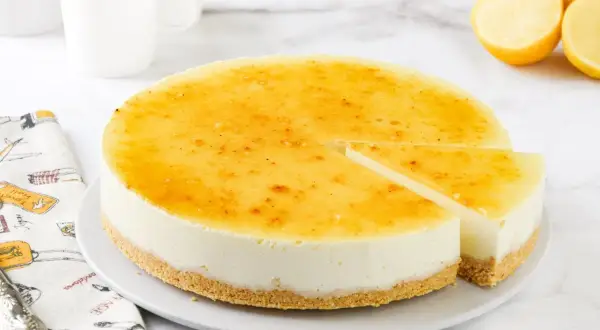 Deliciosa tarta de limón sin horno, con una base crujiente y un relleno cremoso cubierto de caramelo dorado.