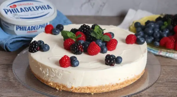 Deliciosa tarta de queso fría cubierta con frambuesas, moras y arándanos frescos. Un postre perfecto para cualquier ocasión.
