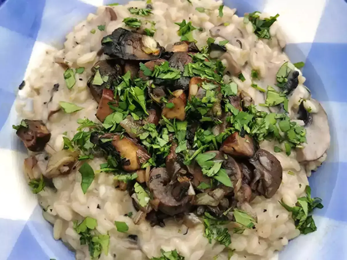 Delicioso risotto de setas cremoso, coronado con champiñones salteados y perejil fresco picado.