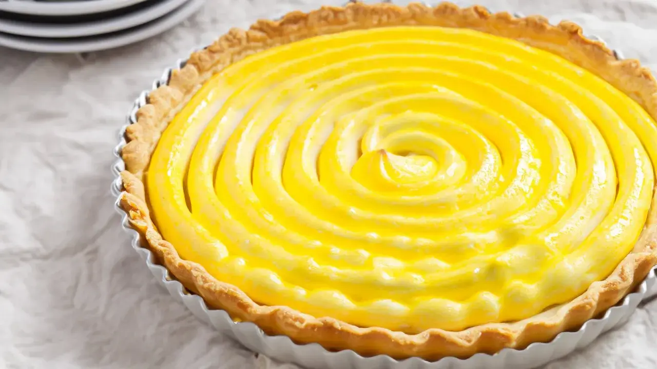 Tarta de limón con merengue, con una espiral dorada y cremosa que invita a probarla.