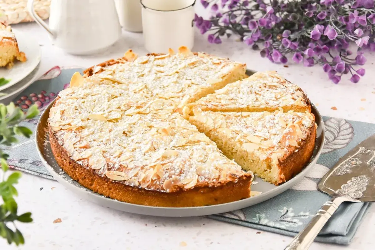 Tarta de almendras dorada y espolvoreada con azúcar glas, lista para servir.