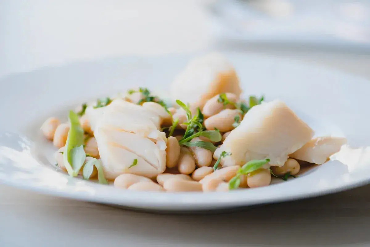 Deliciosa ensalada de bacalao con tiernos garbanzos y hierbas frescas, un plato ligero y sabroso.