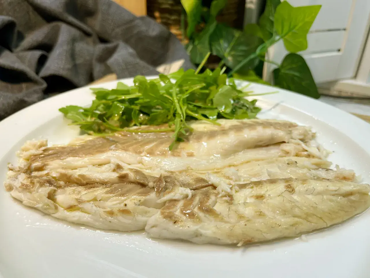 Lubina a la sal jugosa y tierna, servida con una fresca ensalada de rúcula.