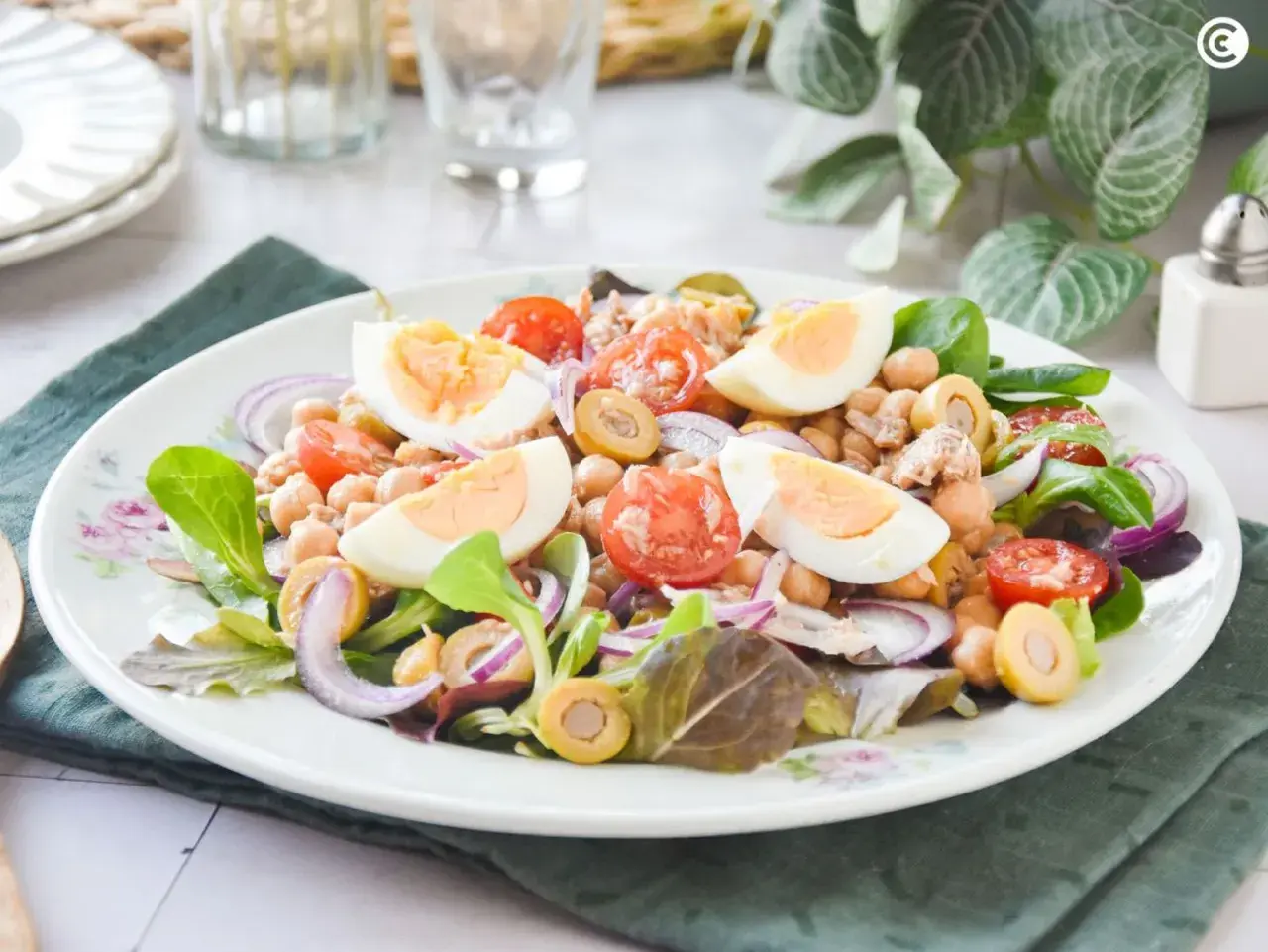 Deliciosa ensalada de garbanzos con huevo duro, tomate, aceitunas y cebolla morada. Un plato fresco y nutritivo.