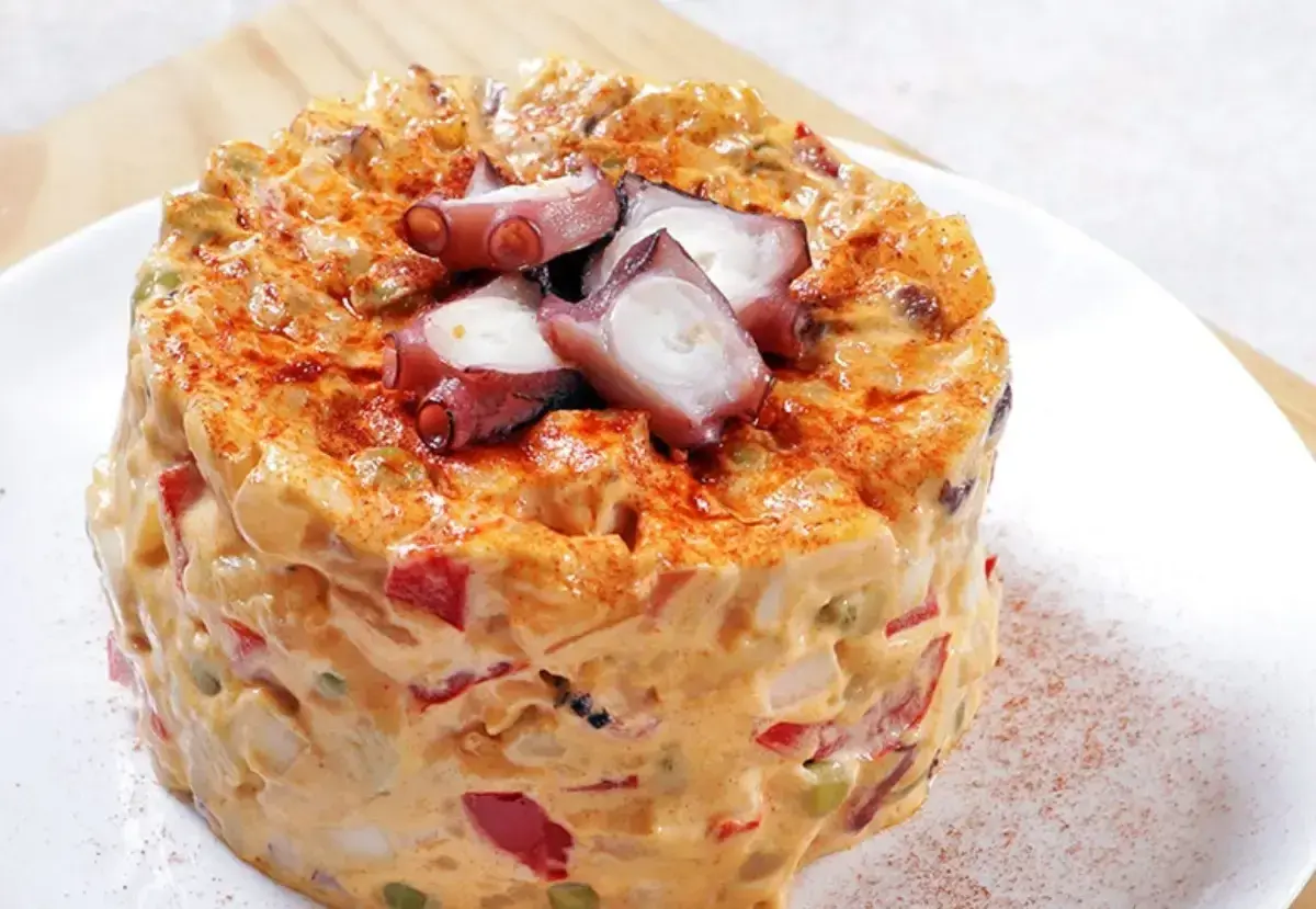 Ensaladilla de pulpo cremosa, con trozos de pulpo tierno y pimentón espolvoreado.