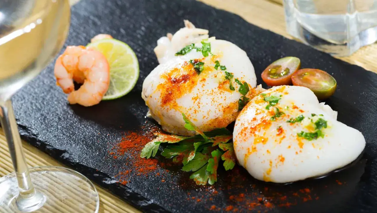 Deliciosa sepia en freidora de aire, servida con gambas, lima y tomates cherry.