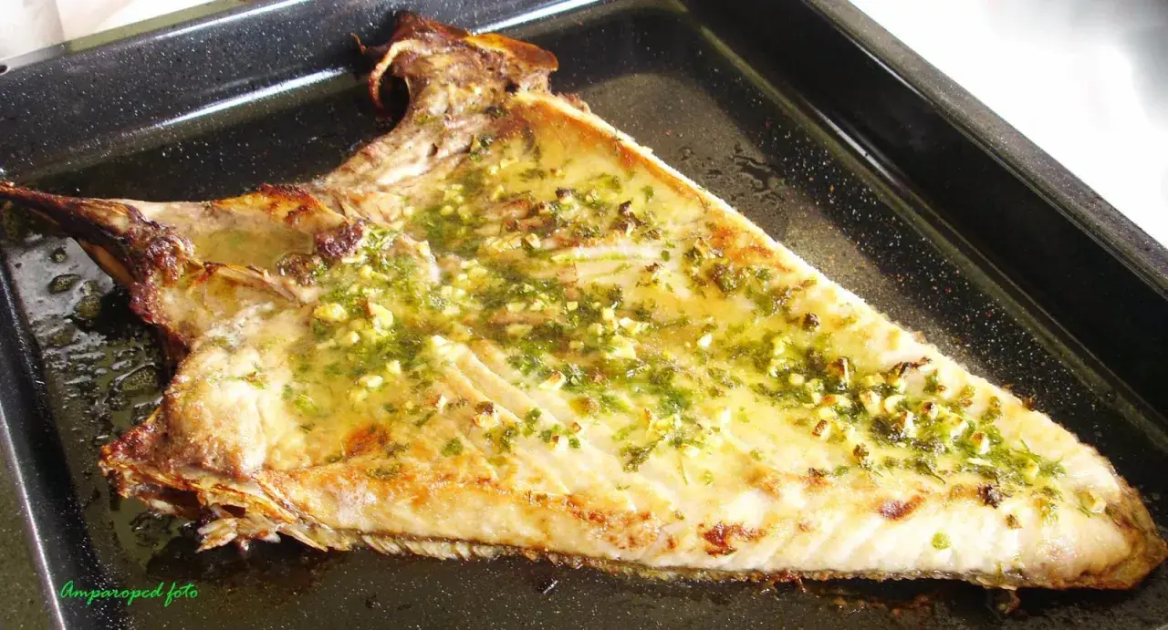 Deliciosa ventresca al horno, dorada y jugosa, con un aderezo de ajo y perejil.
