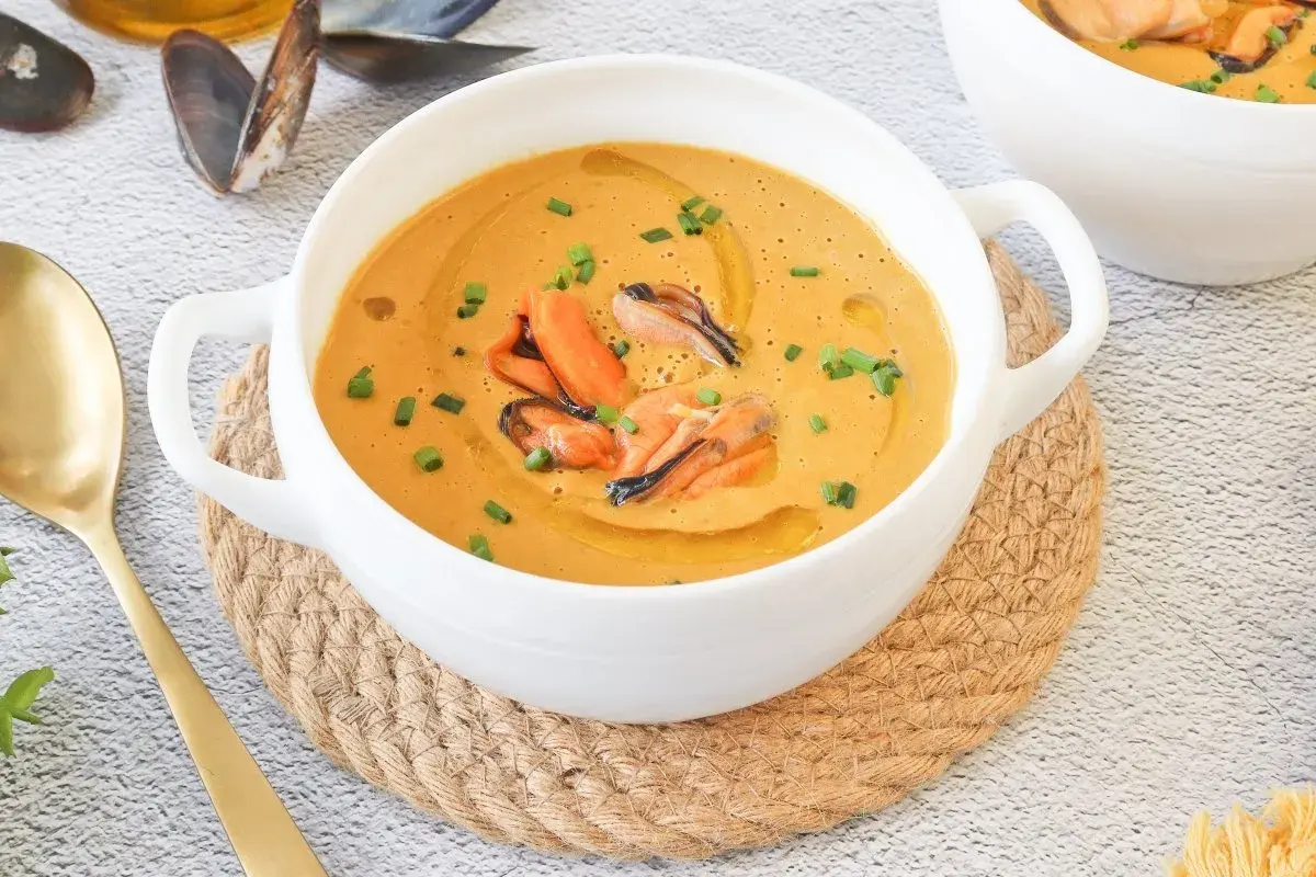Crema de marisco con mejillones, un delicioso pate de mejillones servido en un cuenco blanco con cebollino y aceite de oliva.