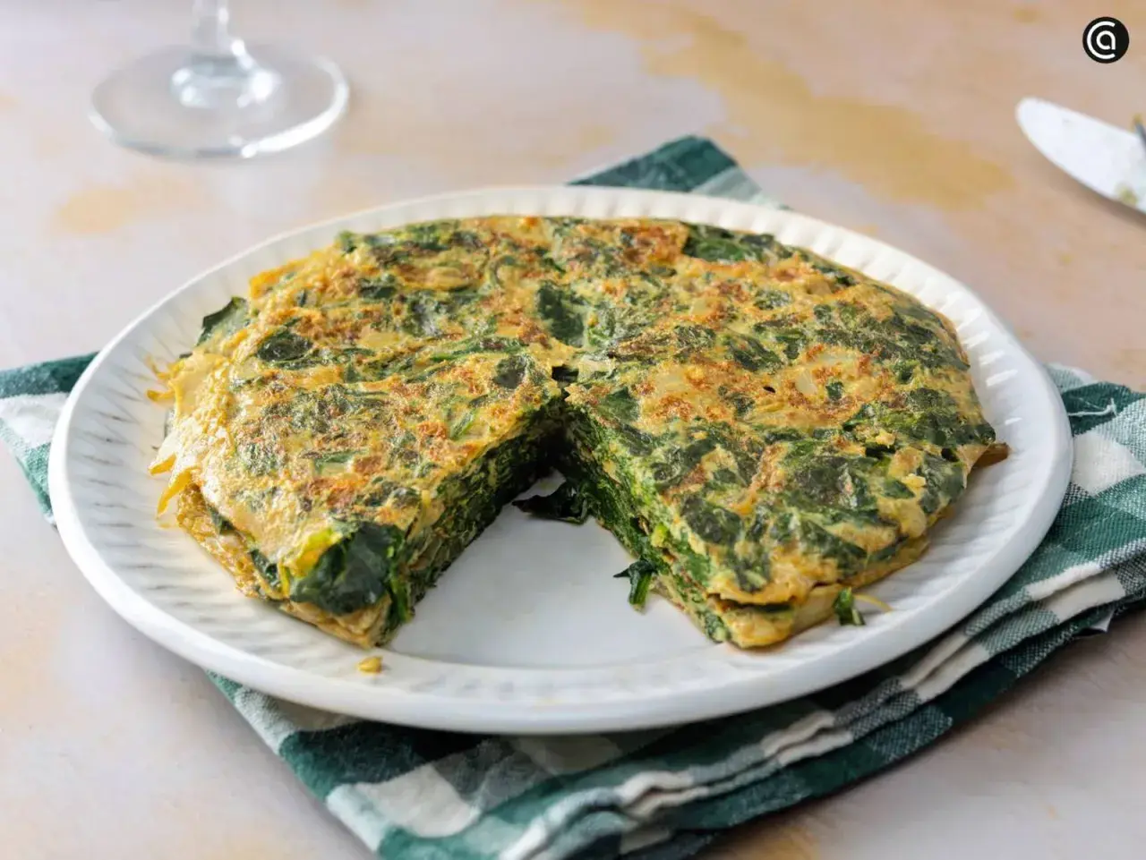 Tortilla de espinacas, un plato casero y saludable. La tortilla de espinacas se ve jugosa y bien cuajada, lista para disfrutar.