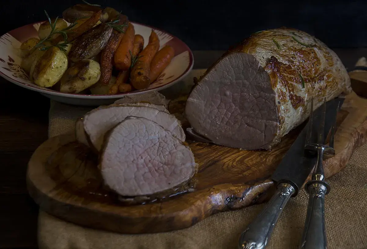 Jugoso redondo de ternera asado, servido con patatas y zanahorias. Un festín para los sentidos.