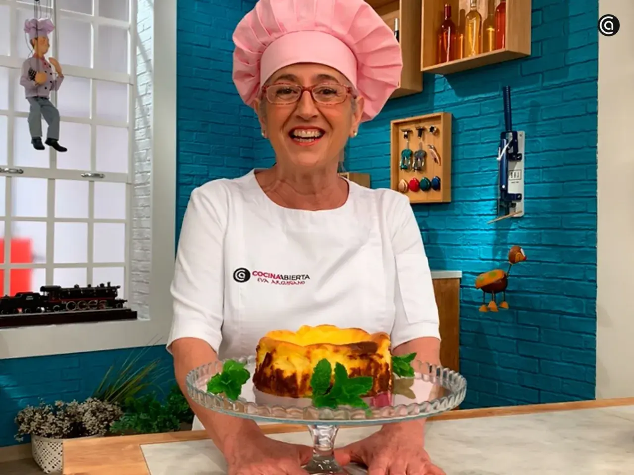 Chef sonriente presenta una deliciosa tarta de queso La Viña, decorada con menta fresca.
