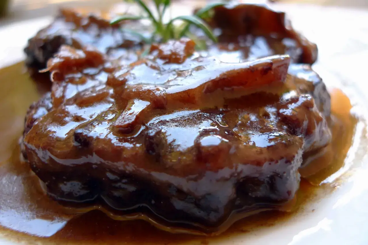 Rabo de ternera estofado, jugoso y tierno, bañado en su propia salsa oscura y aromática, con un toque de romero fresco.